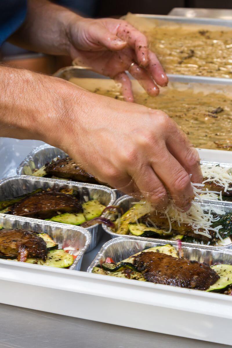 Un traiteur qui confectionne des barquettes-repas à livrer