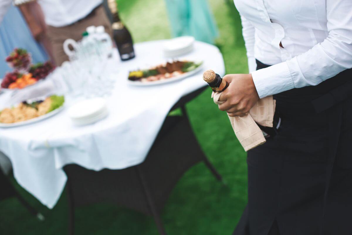 Un traiteur ouvre le champagne pour un mariage