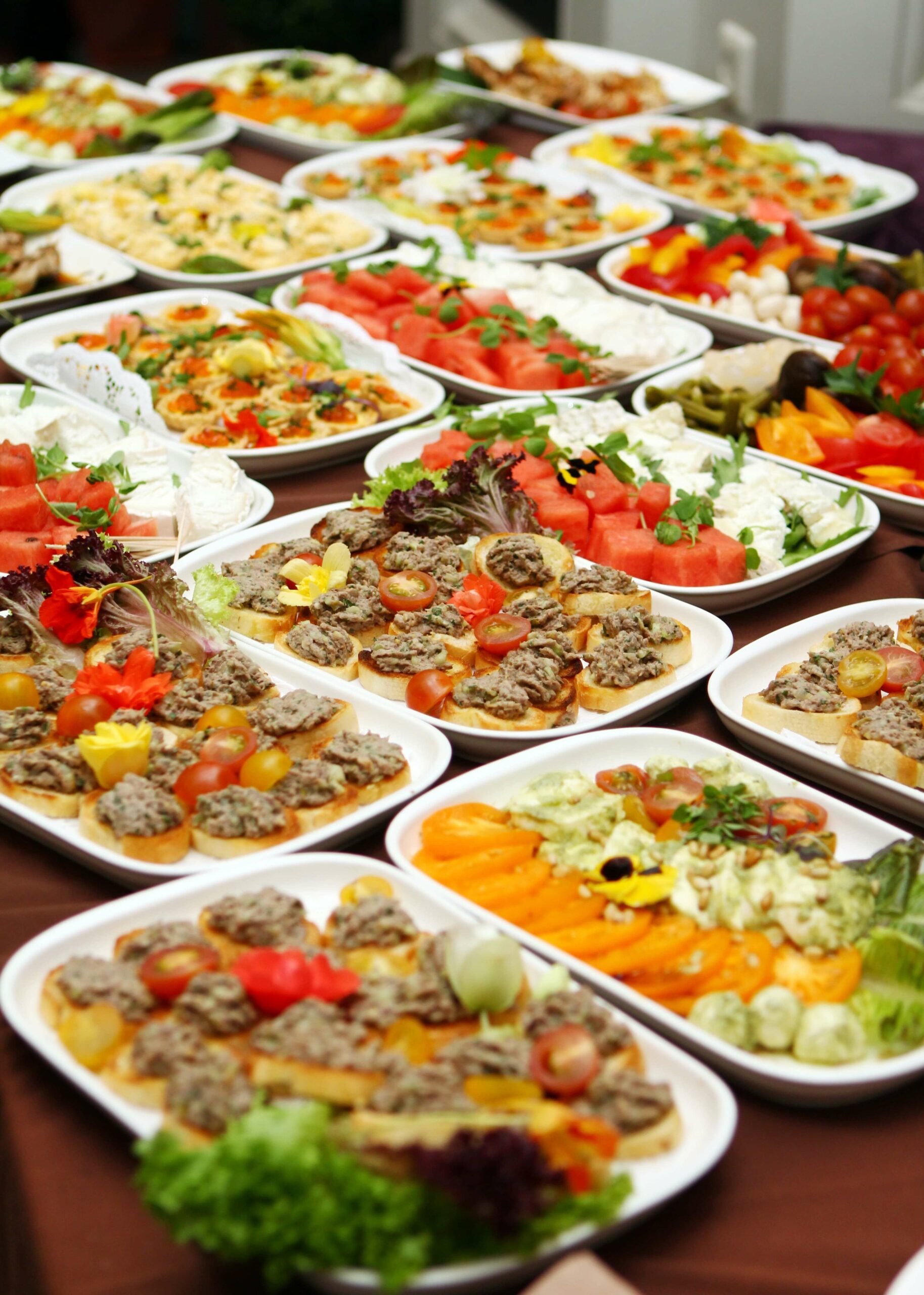 Assortiment de plateaux repas Chez Annie avec tartinades, canapés, pastèque et plateaux de légumes frais.